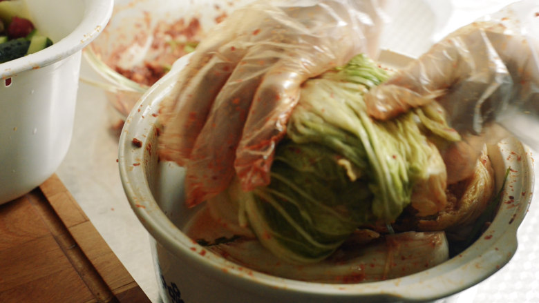制作自家口味的韩式泡菜,将白菜卷起来。这样可以使白菜少出水，味道浓郁。