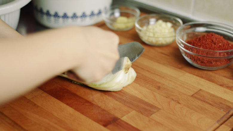 制作自家口味的韩式泡菜,把白菜根部脏的部分切掉。