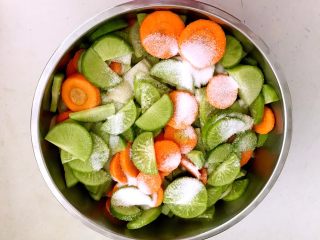 开胃小菜 脆爽萝卜,把绿萝卜片和胡萝卜片放入盆中，加入精盐