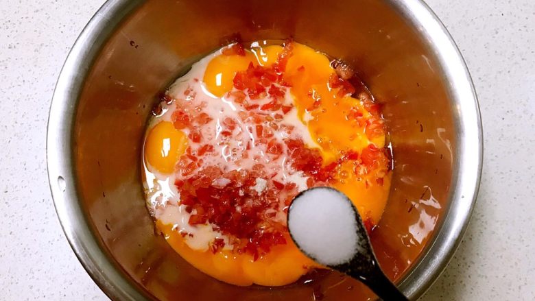 双色厚蛋烧,把西红柿末加入蛋黄中，加入一勺水淀粉，加入2克精盐，调匀备用