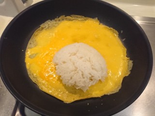 咖喱蛋包飯,盛一碗飯，倒到蛋皮上，位置靠邊些。看得出其實蛋汁還沒全熟吧！別看了！快做下一步！
