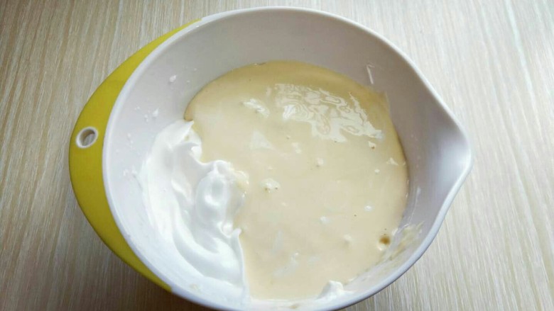 #感恩节食谱#米老鼠蛋糕片,最后将蛋黄糊倒入蛋白霜的容器中，继续翻拌的手法，直至看不到蛋白霜即可。