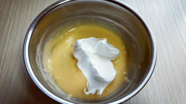 #感恩节食谱#米老鼠蛋糕片,用硅胶刀取三分之的蛋白放入蛋黄糊容易中，翻拌均匀(切记手法，不要划算搅拌，以免消泡) 从底下往上翻拌，手法要轻轻的。
再取三分之一的蛋白霜加入蛋黄糊中，继续上面的手法，翻拌直至看不到蛋白霜。