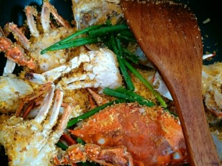 避风塘炒蟹,加入葱段炒至面包糠、蒜末裹在蟹块上为止