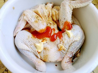 #感恩节食谱#秘制烤鸡,先将其身上撒上一些花椒碎和黑胡椒碎。再放上，番茄酱和黄油。生抽料酒。
