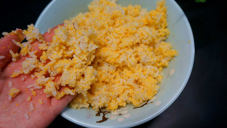 黄金玉米饭,用手搅匀，让米饭和玉米粉彻底综合在一起，在这个过程当中要用手感受一下干不干，太干蒸起来不好吃
