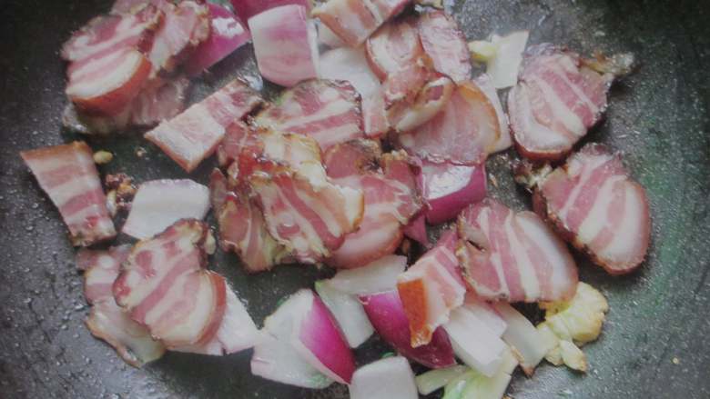 腊肉土豆片,倒入腊肉翻炒，小火慢慢煎煮，直至腊肉肥肉微微发焦，油脂煎出来