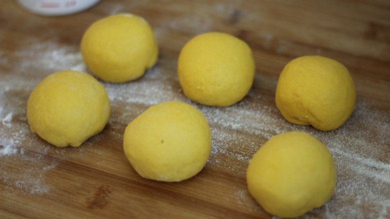 金灿灿的南瓜馒头,发酵好的面团取出反复按压排气，分成6个等大的小面团。