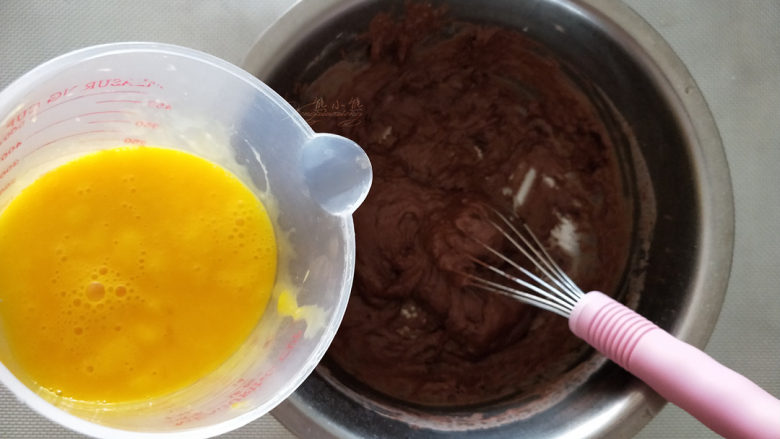 可可软嫩蛋糕,全蛋和蛋黄放在一起打散。慢慢加入，搅拌均匀。