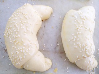 #最爱面包#黑米馅牛角包,取出刷蛋液，撒少许白芝麻，同时烤箱预热