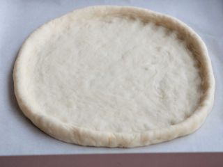 熏肠披萨,移至烤盘上整形成披萨的形状