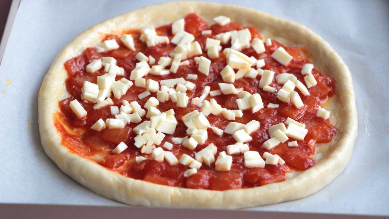 熏肠披萨,铺上一层西红柿酱、再撒一层芝士