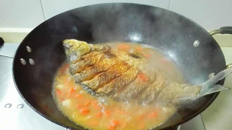 糖醋胡萝卜鳊鱼,轻轻的给鱼翻个身，盖锅盖中火烧十五分钟