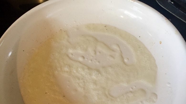 地道的美式早餐之——推滑蛋,用锅铲把融化过程中的黄油摊匀在平底锅上。
