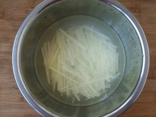 快手香辣土豆丝,把切好的土豆放入清水中防止氧化。