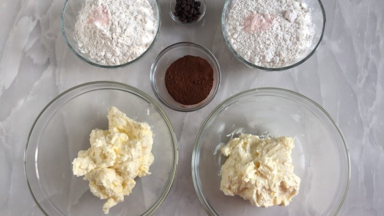 巧克力双色曲奇,将打发好的黄油平均分成两份，粉盐也分为两份，分别放入两份面粉里。