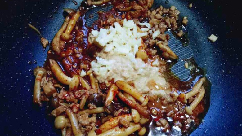 一碗面条＋花生酱蟹味菇肉丁面,加入蒜末，煸炒2分钟即可出锅。