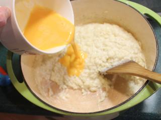 香橙米蛋糕,分2-3次将蛋液加入米饭，拌匀。