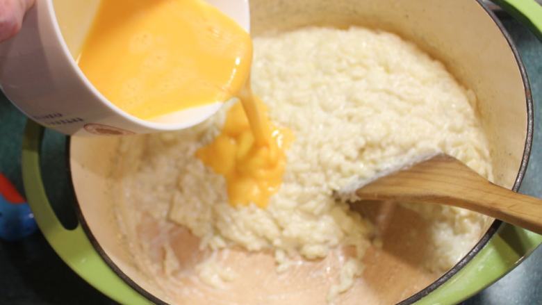 香橙米蛋糕,分2-3次将蛋液加入米饭，拌匀。