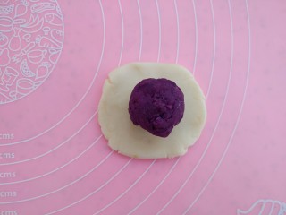 紫薯葵花酥,15分钟后，取一个面团，按扁包入紫薯
