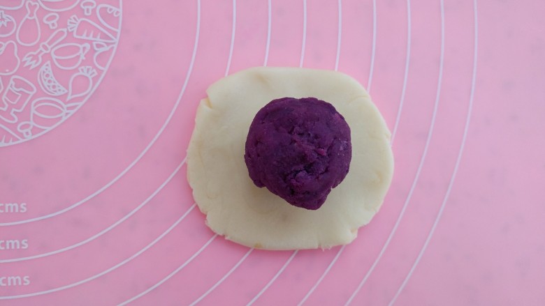 紫薯葵花酥,15分钟后，取一个面团，按扁包入紫薯
