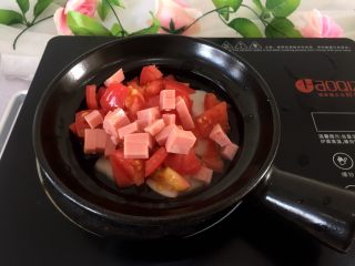 砂锅年糕煲,将西红柿洗净切块，将火腿切丁放煲中