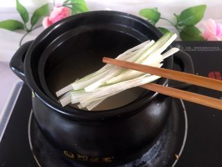 韩式年糕汤,将大葱洗净切段，放入煲中