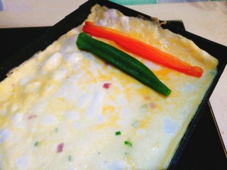 阳光早餐～秋葵厚蛋烧,将秋葵和胡萝卜条放在蛋饼一边