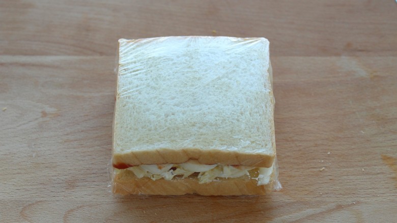 沼夫三明治,用保鲜膜将三明治包起来