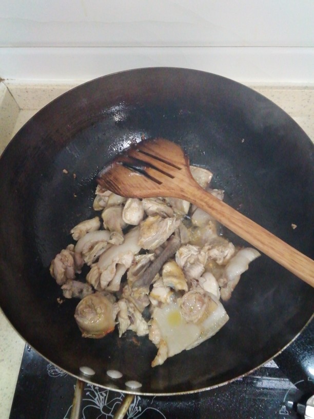 小鸡（野鸡）炖蘑菇,锅内加菜籽油（熟油），油至七成热加入五花肉煸炒出油再加入鸡块一起煸炒