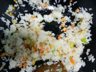 蒜黄炒米,胡萝卜粒炒软，放入隔夜米，搅拌均匀。