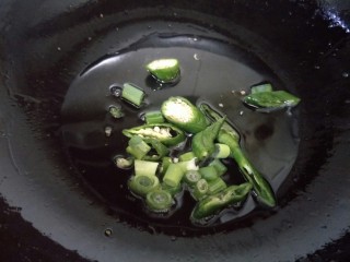 杂蔬炒鸡蛋,锅中加油，烧热，放入葱花和青椒炒香。