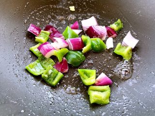 菠萝咕噜肉
,锅里放三分之一汤匙食用油，炒一下青椒和洋葱片，炒均匀。