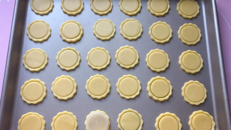 纽扣饼干,然后用小圆形模具在圆饼上压出一圈痕迹，七、八分深度就可以了，千万不要压到底哦。