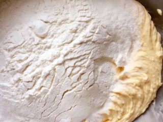 纽扣饼干,筛入泡打粉和低筋面粉，用硅胶铲翻拌均匀，至无干粉。