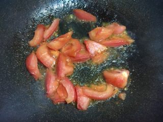 蚝油双菇拌面#一碗面条#,锅内入食用油烧至七成热，倒入番茄块煸炒出汁。