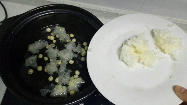 银耳莲子粥,砂锅中放入适量水，放入洗净的莲子、银耳的一半。