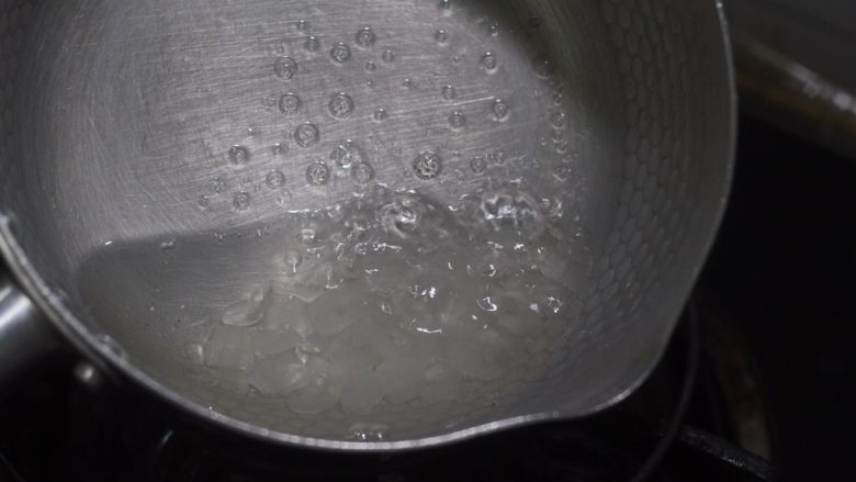 老北京小吃之冰糖葫芦,中小火摇滚着锅，让冰糖快速融化在水里。