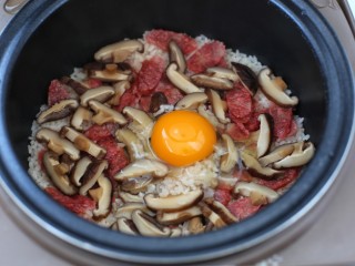 电饭煲腊肠煲仔饭,待米饭呈保温状态时，打入一个鸡蛋盖上锅盖闷5-8分钟
