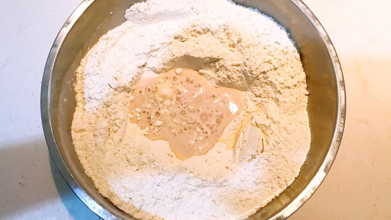 奶香花卷,把酵母水倒入面粉中搅拌均匀，再加入凉开水和面