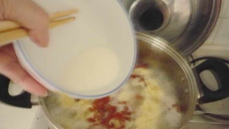 马蹄玉米蛋花羹,一边搅拌锅中汤水一边将其慢慢倒入勾芡。