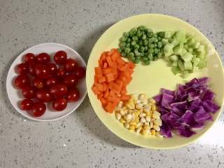 彩虹蔬菜馒头沙拉,把胡萝卜、黄瓜去皮切丁，紫甘蓝洗净切成小片，圣女果、豌豆洗净，玉米粒剥好。