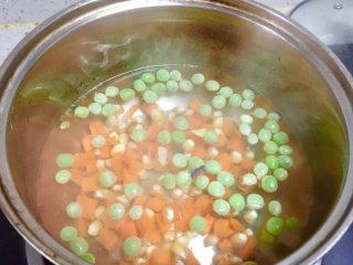 彩虹蔬菜馒头沙拉,把胡萝卜丁、玉米粒、豌豆下沸水焯熟。