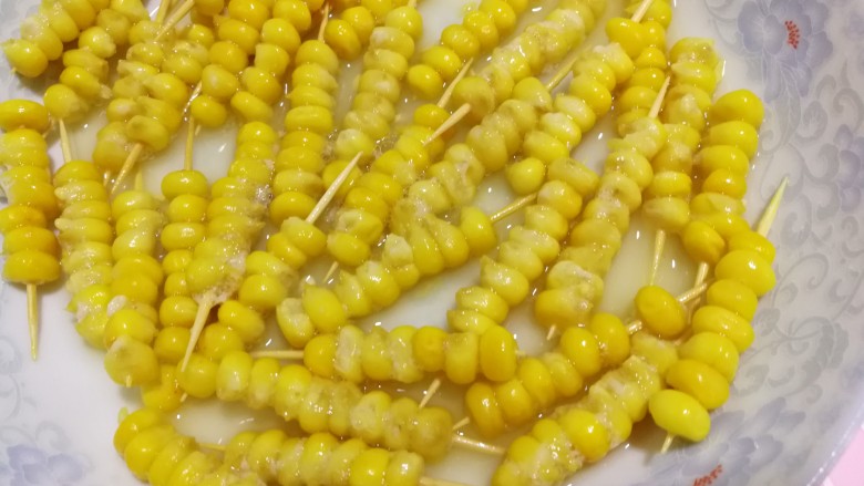 甜蜜的黄金米粒,穿好的玉米粒儿泡过后再放到一个平盘内，将剩下的蛋液淋在上面。
