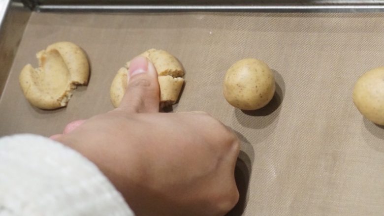 咖啡樱桃玛格丽特高纤饼干,用拇指指腹将小圆球面团逐个压扁；