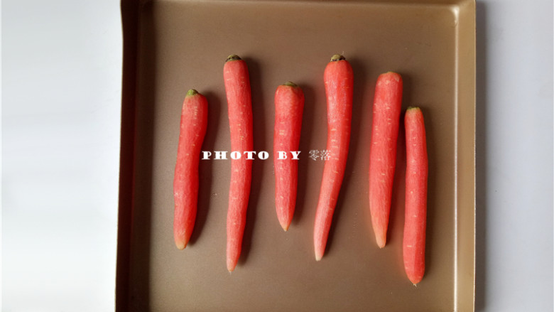 秘制烤胡萝卜,将胡萝卜放进不粘烤盘；如果烤盘会粘，需垫锡纸或油纸；