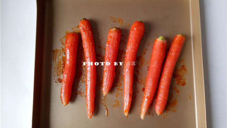 秘制烤胡萝卜,将黄油混合调料刷在胡萝卜上，翻面，继续刷，直至胡萝卜全身都粘上调料；