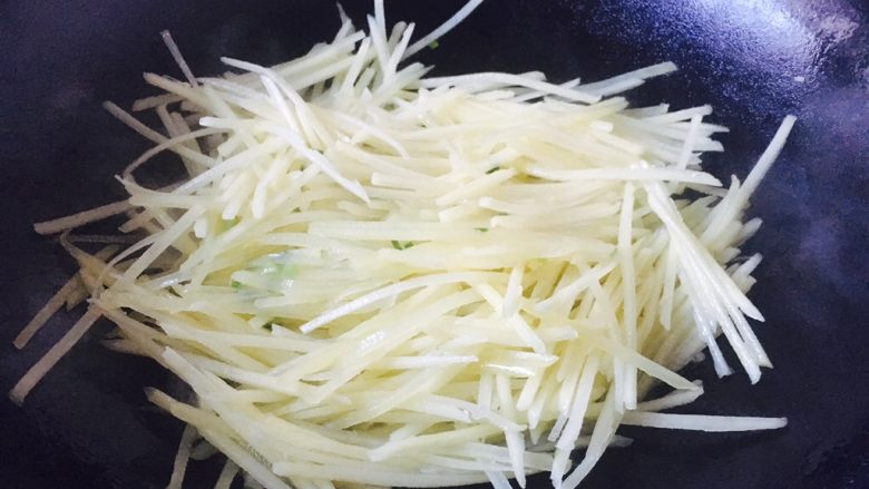 #圆土豆# 花椒油青椒土豆丝,迅速翻炒均匀，并且不断翻炒。