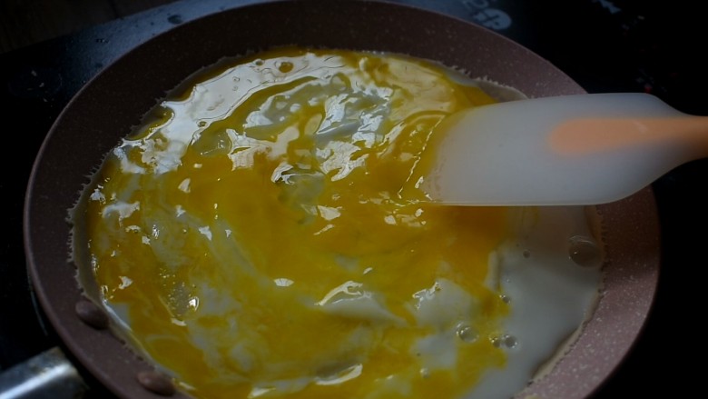 杂粮卷饼,用铲子将鸡蛋打散，摊平