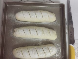 法棍面包,放置温暖处，发酵至原来的两倍大。筛上一层面粉。用刀子割出小口。